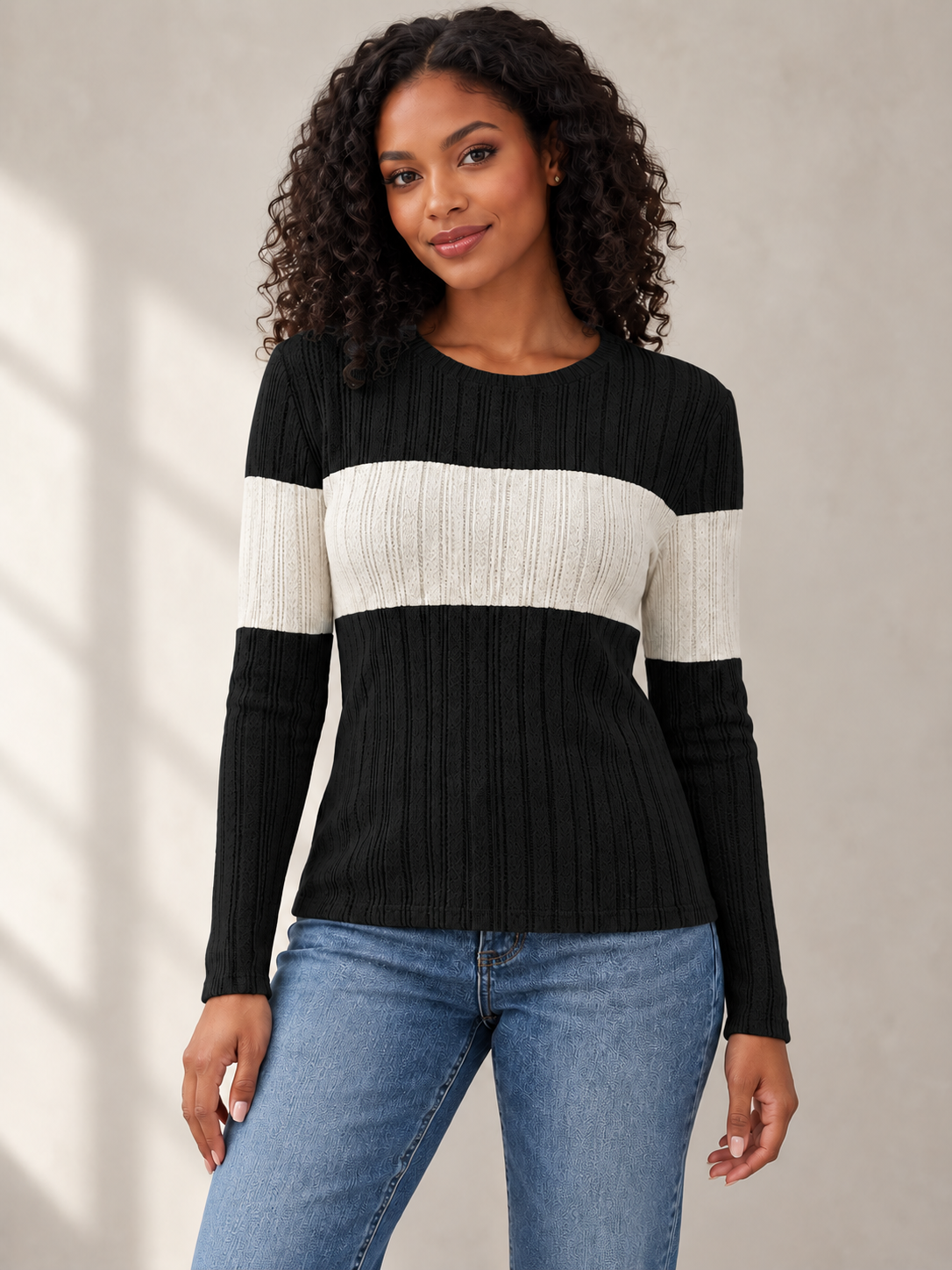 front view of female model wearing black knit top with ivory contrast band